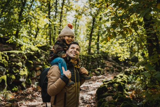 Father carrying child on shoulders in nature